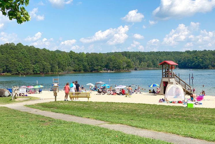 The lively beach at Smith Mountain Lake State park with sun, sand and colorful umbrellas