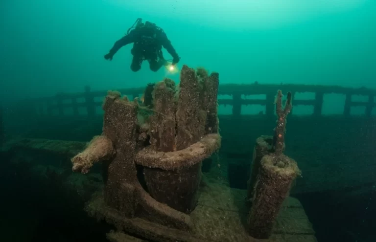 A scuba diver explores an old, wooden shipwreck in Lake Michigan