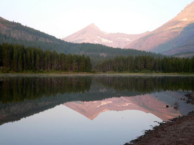 View of Mountains From Shoreline of Forest Lake